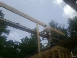 Carpenter setting a ridge beam over a new addition frame — Ice Dam Removal by Roofing Brothers in Haddonfield