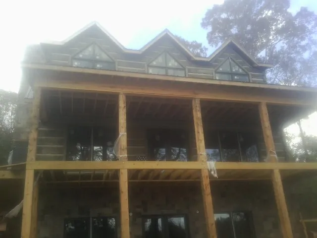 Dormers and porch framing on a large log home under construction — Roof Coating work by our crew in Haddonfield