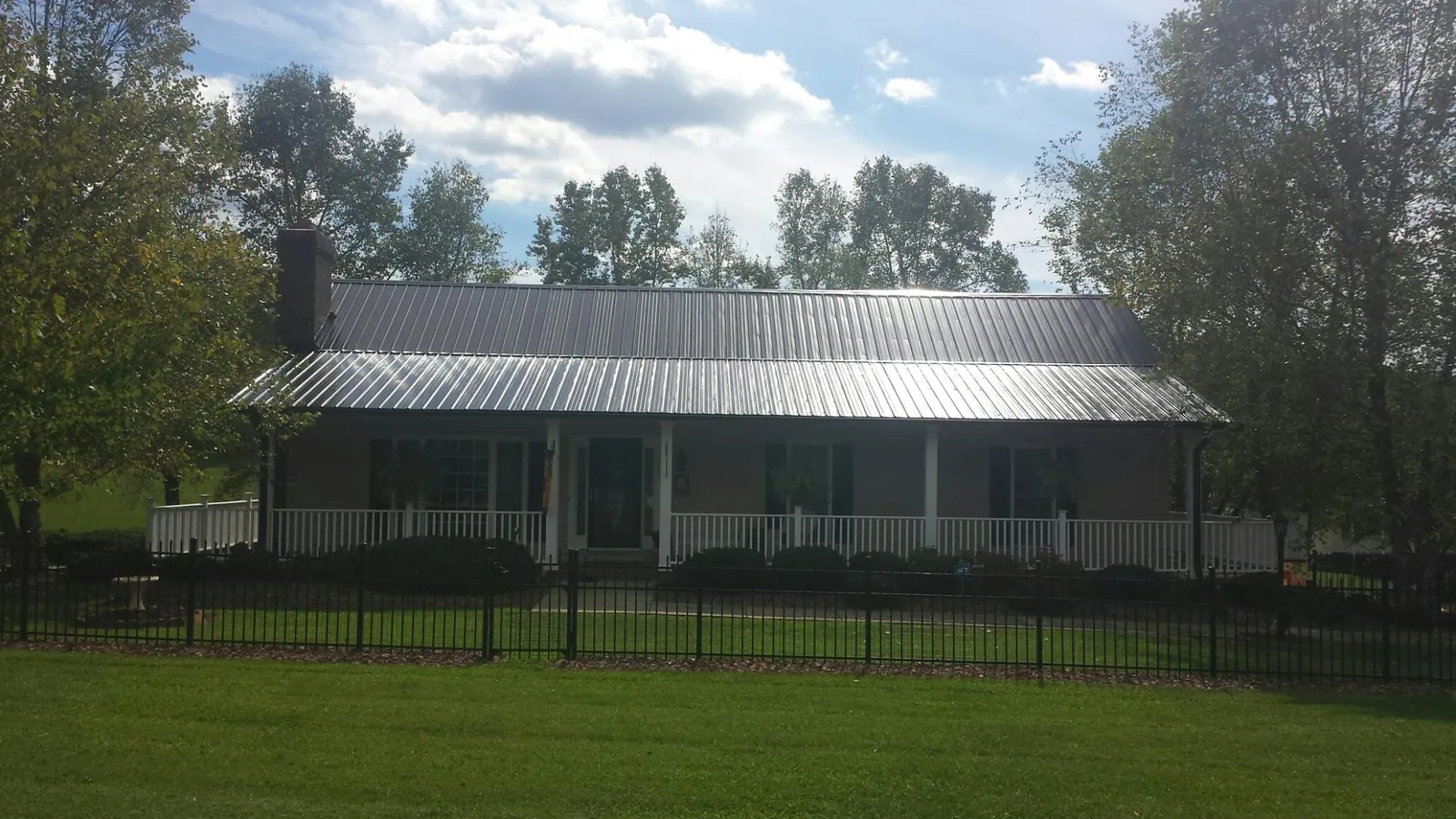 Gray metal roof on a brick ranch with a full width front porch — Gutter Guard Installation work by our crew in Haddonfield