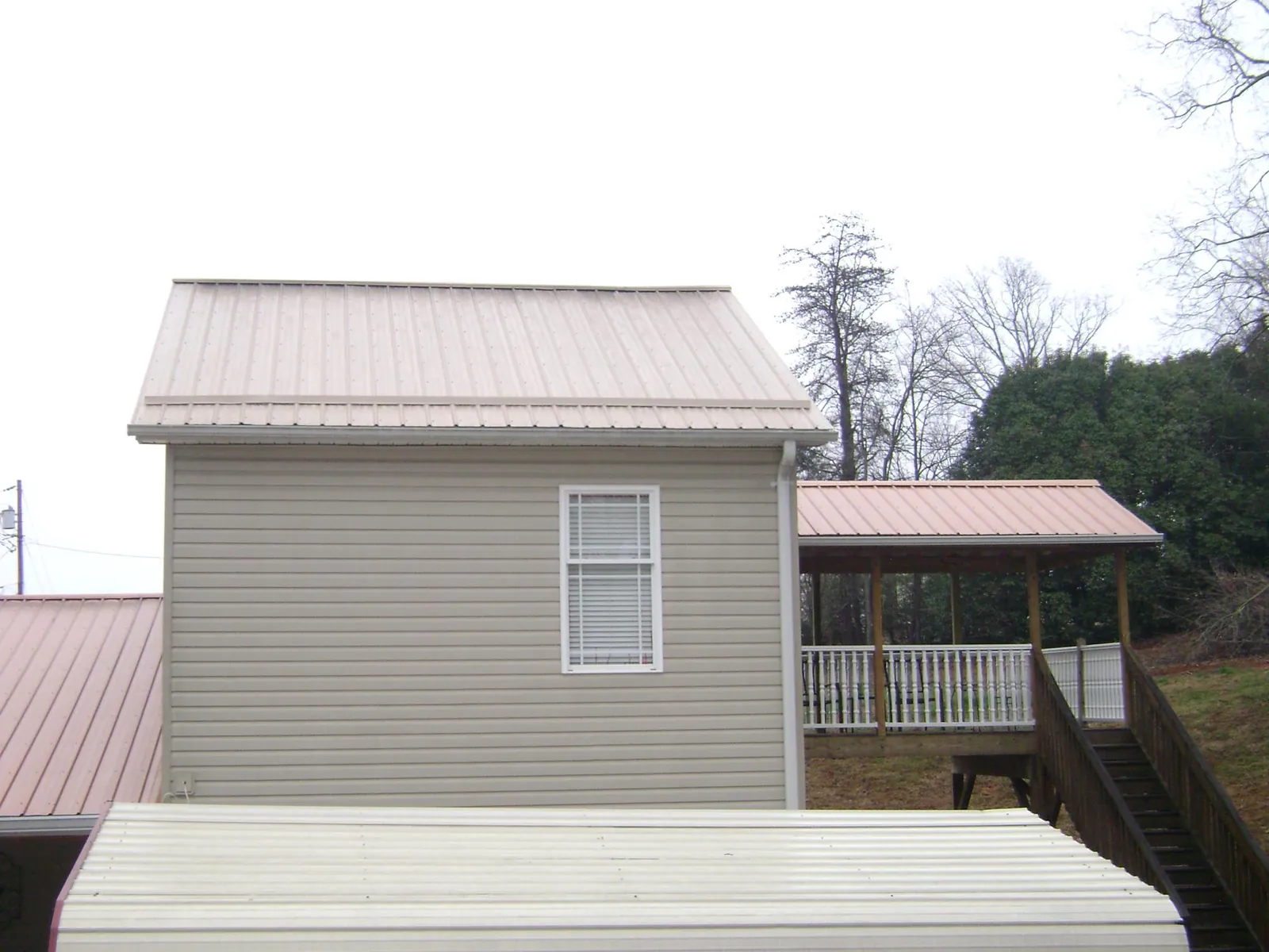 Tan metal roofs on a two story addition and attached porch, from a Roof Replacement job in Haddonfield